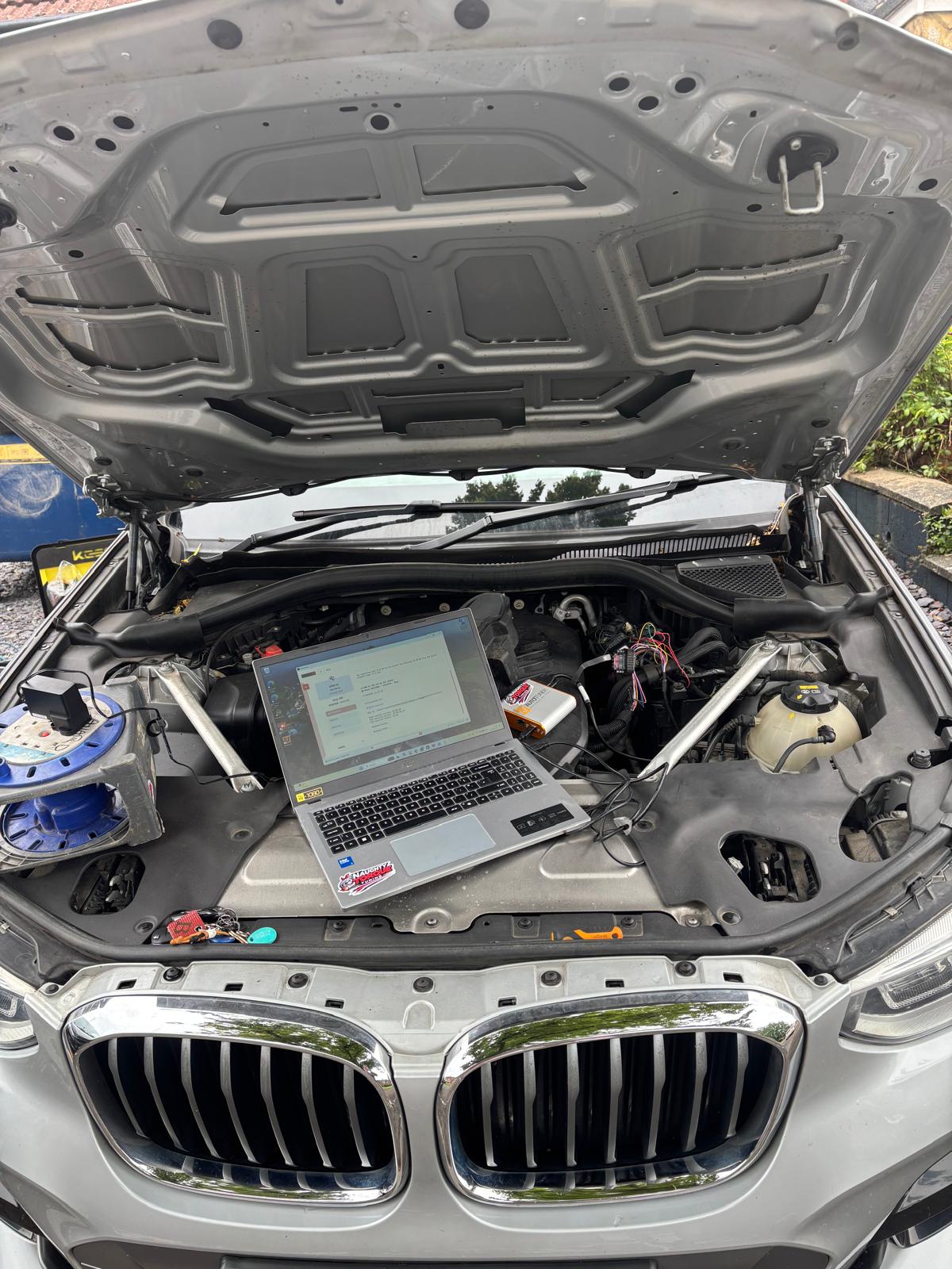 BMW X3 remap in progress — laptop connected in the engine bay